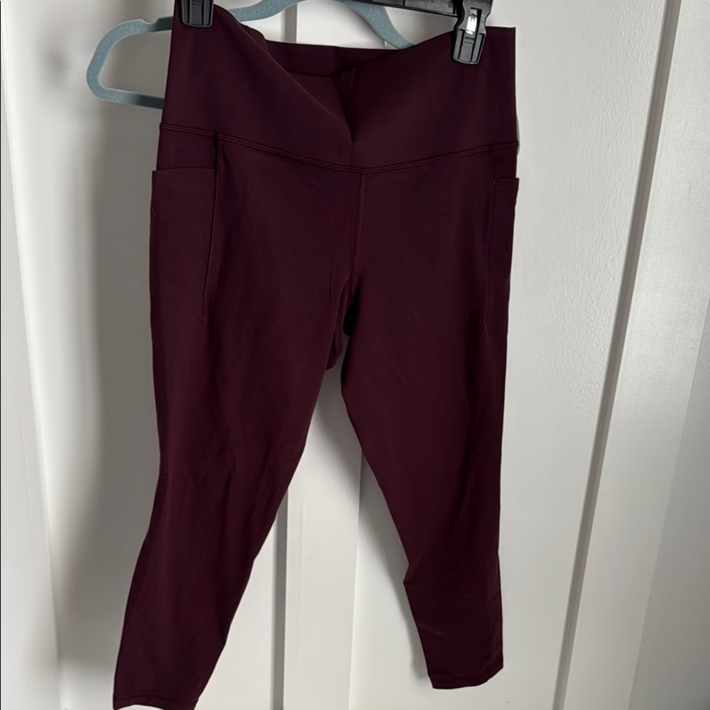 Athleta salutation stash pocket 7/8 tight. NWOT. Large burgundy colored